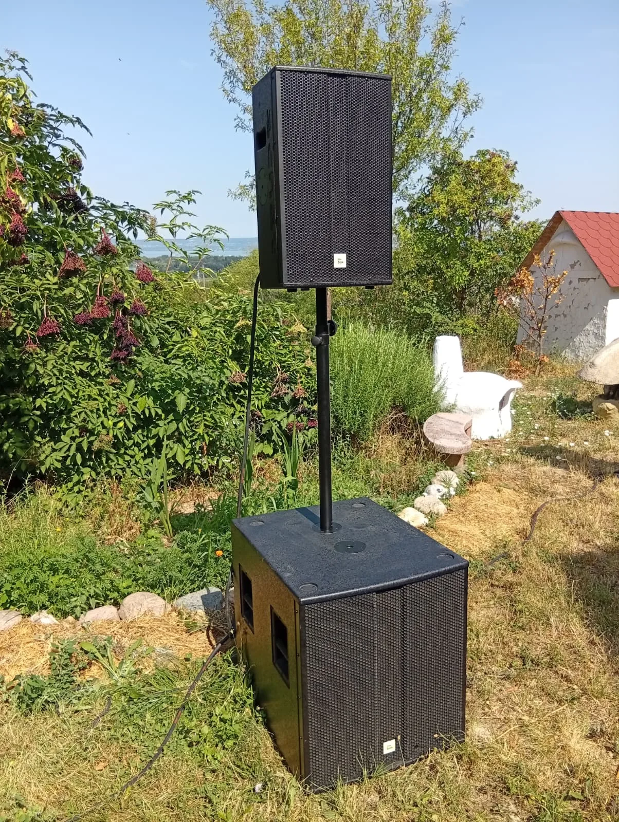 PA-Top auf Stativ über einem Subwoofer, aufgebaut auf einer Wiese