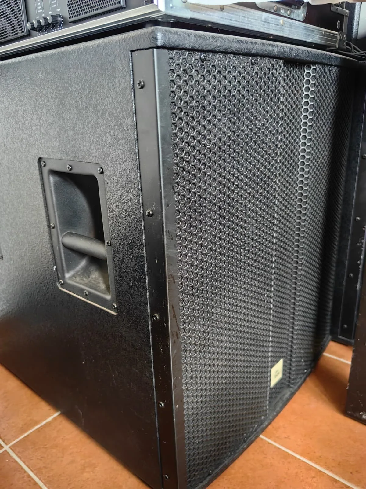 Subwoofer aus der Nähe: Bassreflexöffnung und Metallgitter der Front